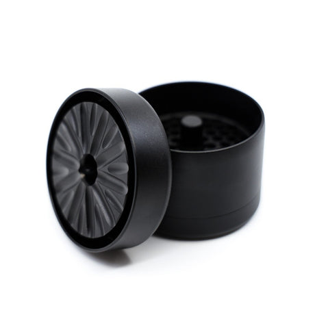 black and grey flowermill 2.5 standard herb grinder with top section removed on white background