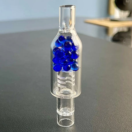 sneaky pete rocket stem for arizer with blue cooling beads sat on grey surface