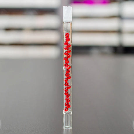 sneaky pete beaded 130mm glass add-a-cap accessory with red beads stood upright on grey surface