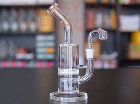 sneaky pete the buzz glass rig paired with 14mm banger sat on grey surface