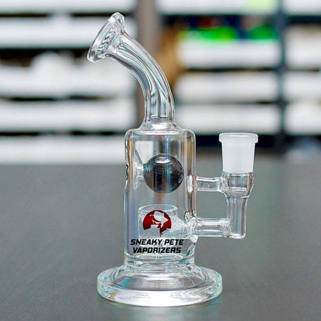 defender glass water rig with sneaky pete branding sat on table