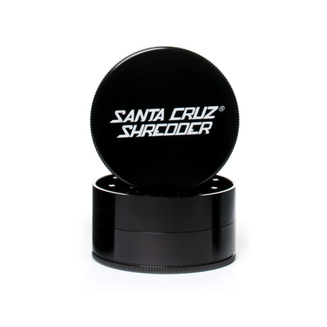 large gloss black 3 piece santa cruz shredder herb grinder with the lid section sitting on top of the base. Santa Cruz logo on lid.