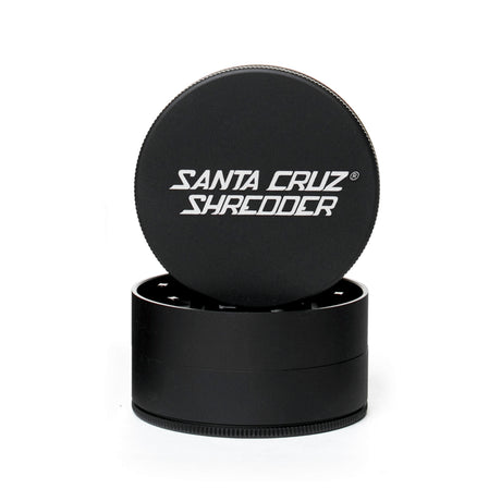 Black 3 piece santa cruz shredder herb grinder with the lid section sitting on top of the base. Santa Cruz logo on lid.